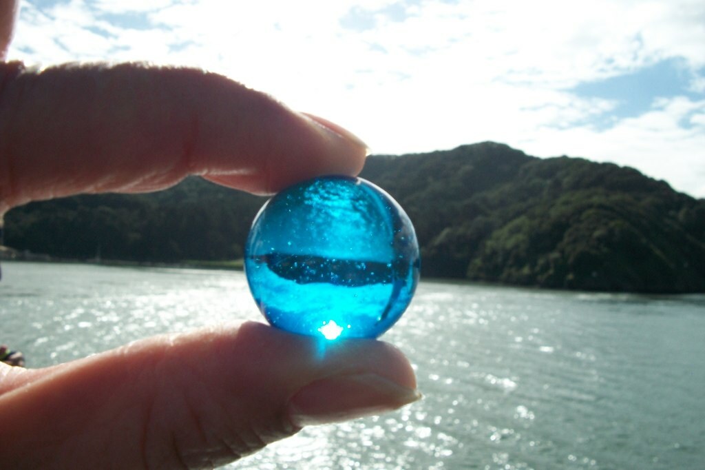 a close up of a blue marble with Angel Island, California in the background